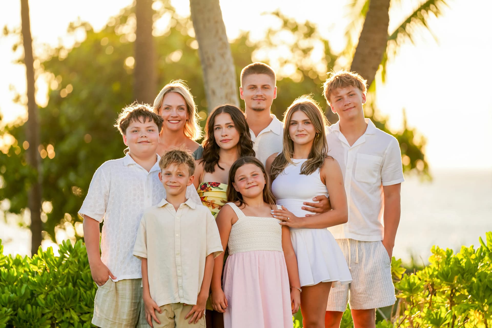 Large family portrait at golden hour surrounded by tropical light